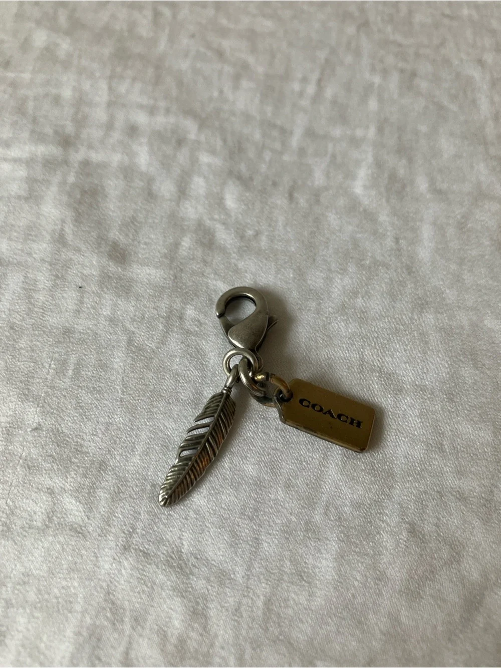 Coach: Silver Tone & Gold Tone Feather Charm Keyring